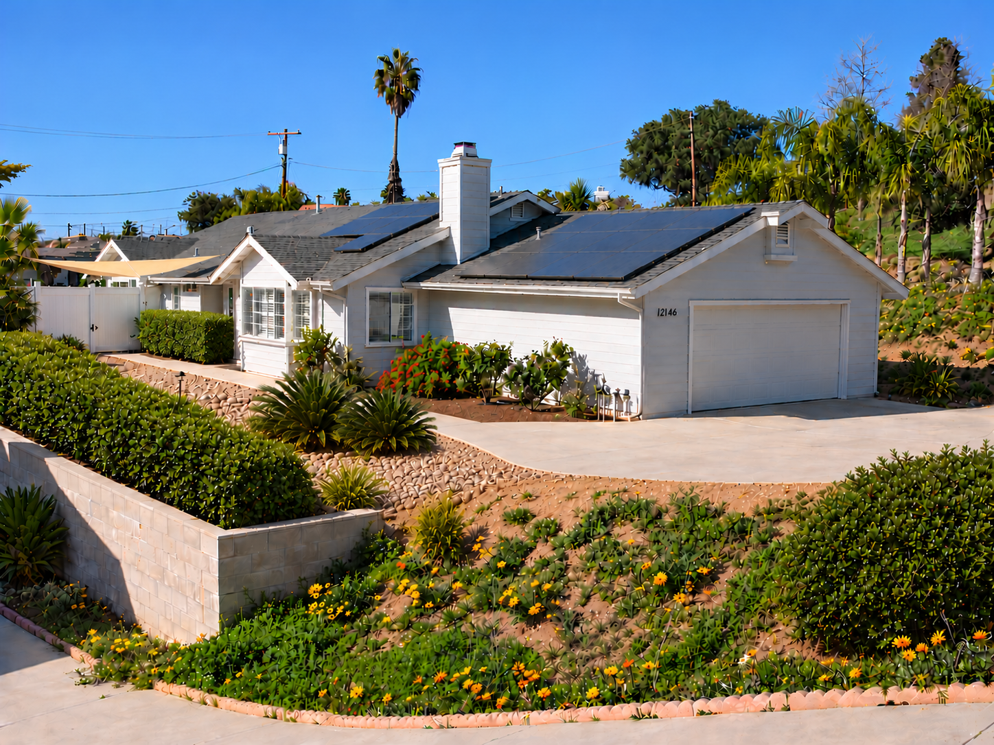 The Sunrise Care home on a clear day, with solar panels on the roof, a two-car garage, and a landscaped front garden